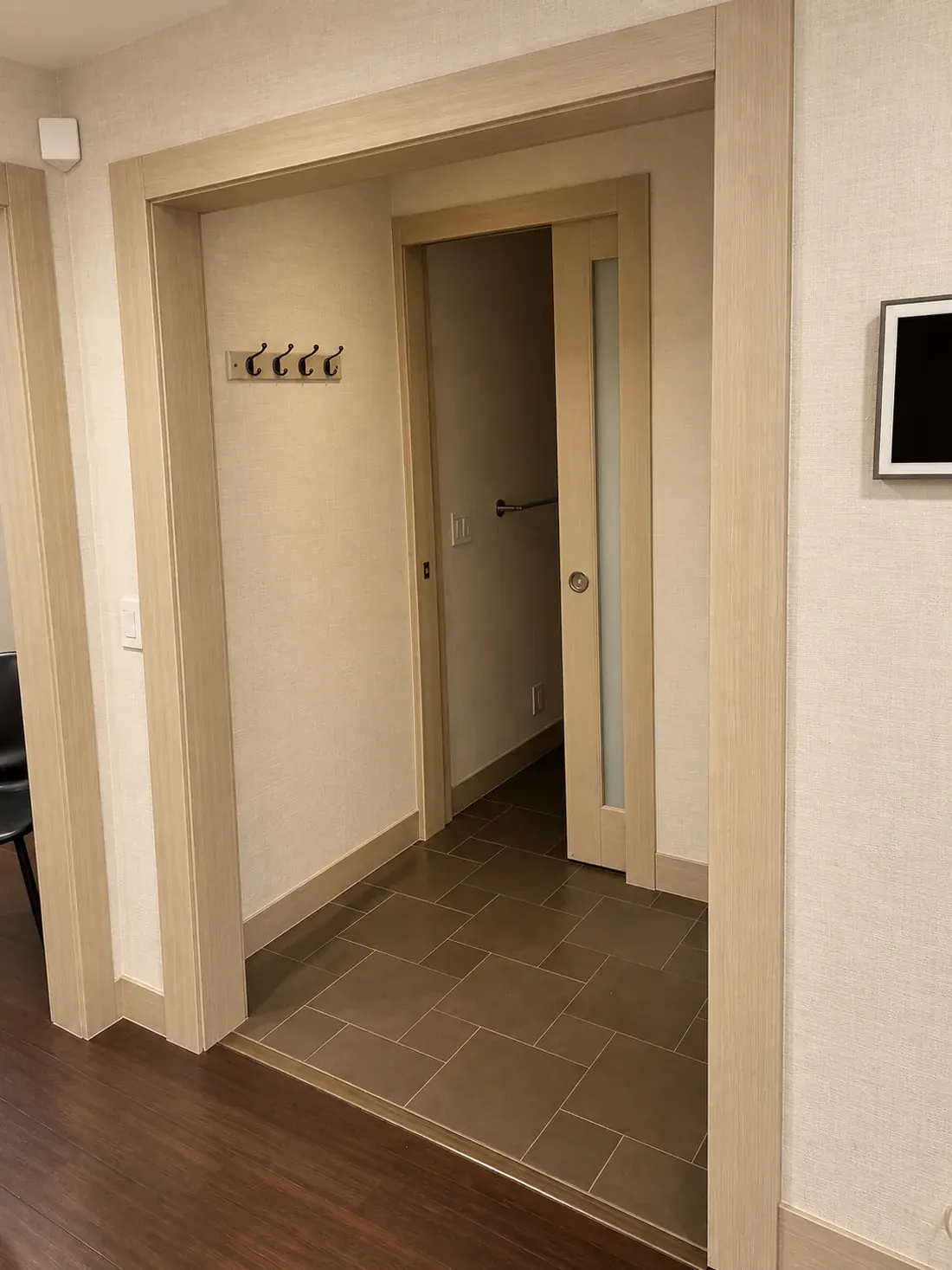 Hallway walls, casings and pocket door wrapped in pale wood-grain interior film